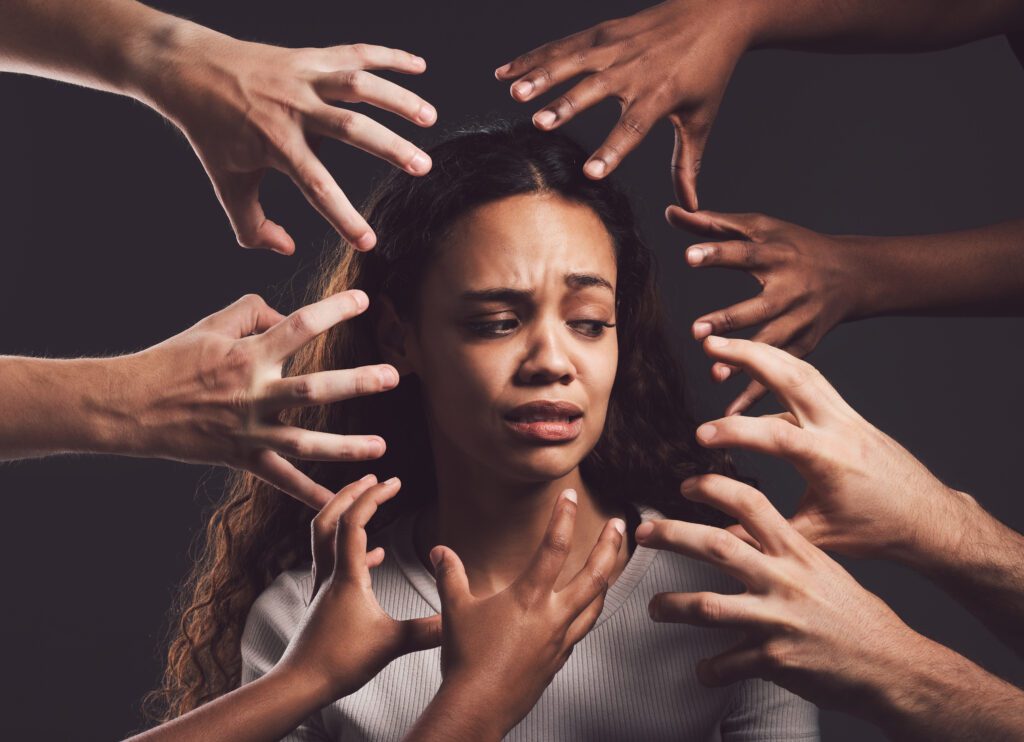 Change perception, negative self talk, Shot of hands grabbing a young womans against a dark background.